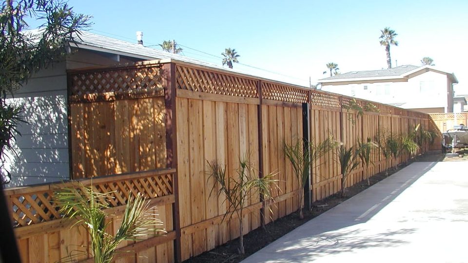 Long wood fence with lattice top along a residential driveway