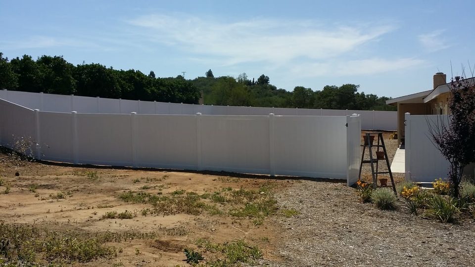 Long white vinyl privacy fence on a rural Valley Center property