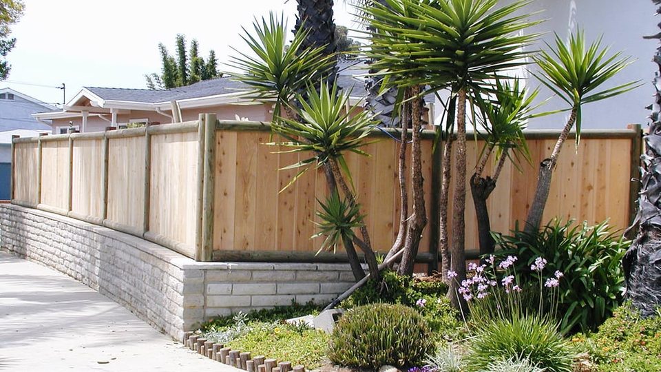 Wood fence and retaining wall repair work on a sloped lot